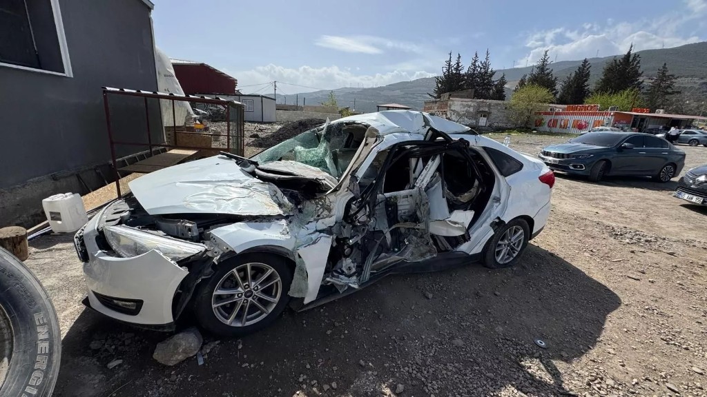 Çatısı ezilmiş ağır hasarlı beyaz sedan
