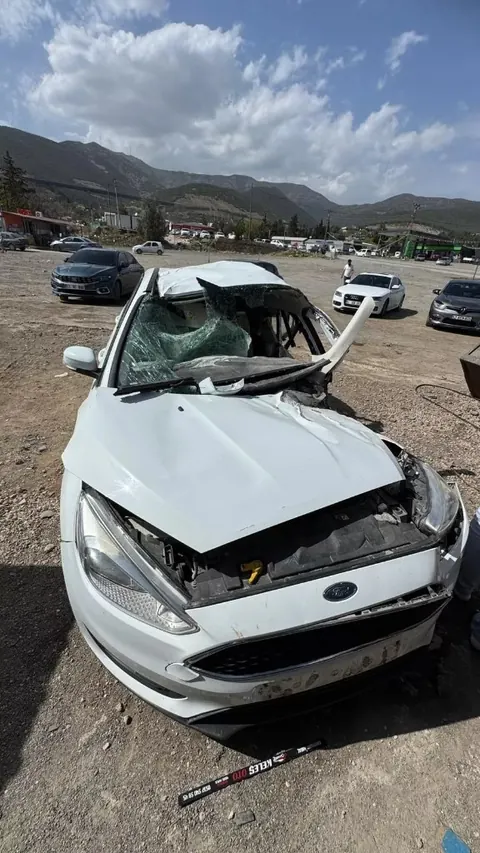 Çatısı çökmüş ağır hasarlı beyaz sedan